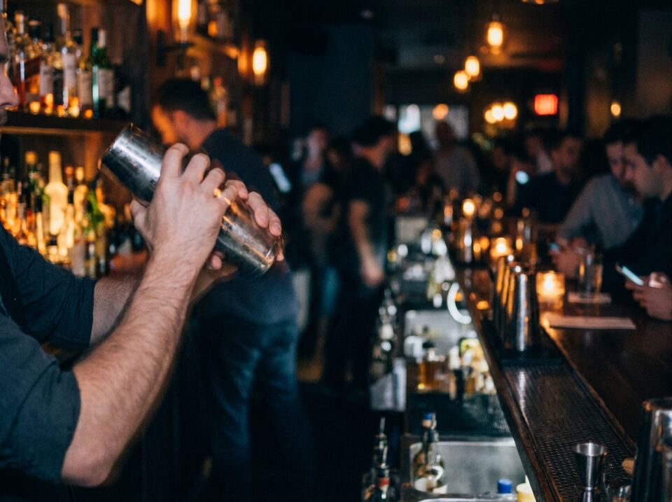 A three-deep bar on a busy night, seen from the working side of the bar.