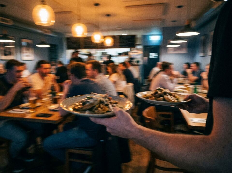 A packed casual dining room at dinner, seen from the service station.
